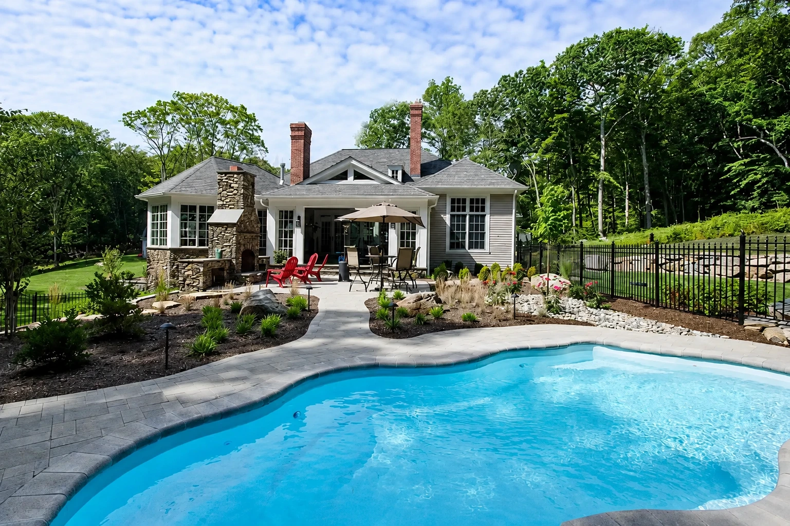 Backyard swimming pool and patio area at a custom home built by Connecticut home builders